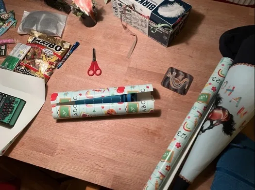 Tisch mit Zuckertüte in genähten Überzug, bedruckt mit Pferdebild und Namen sowie kleinen Geschenken und Süßigkeiten, bereit zum Verpacken