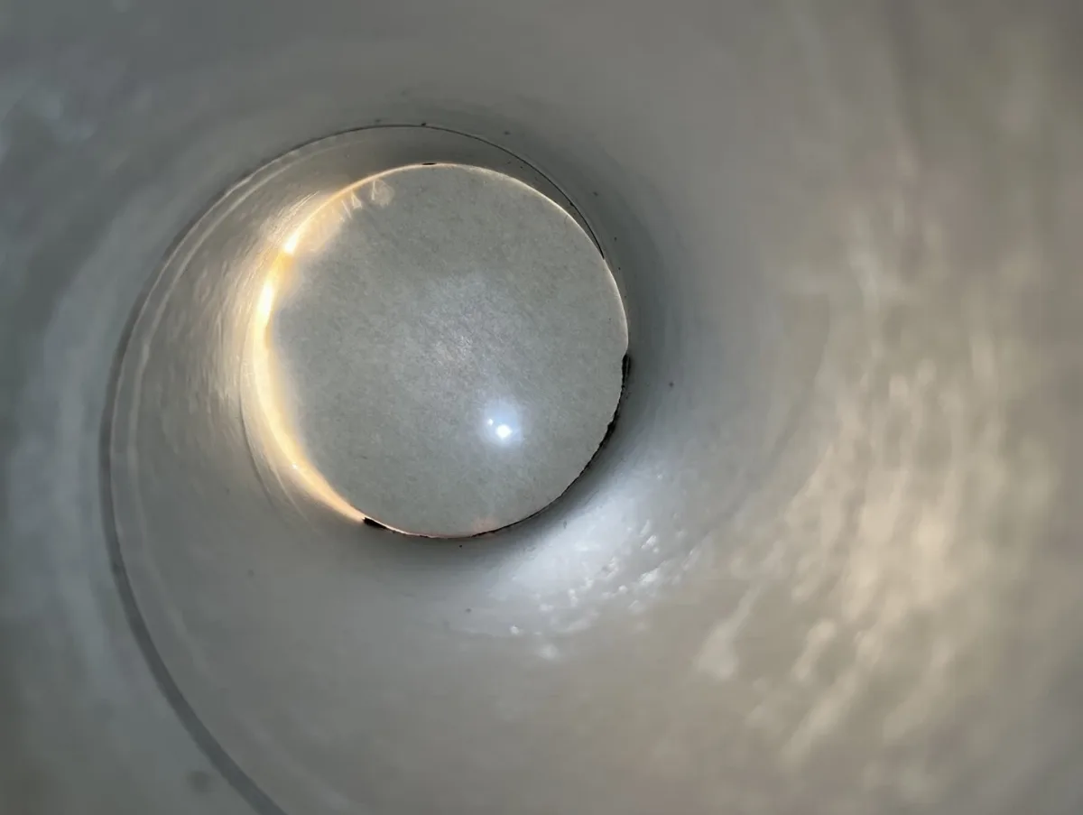 Blick in eine selbstgebaute Lochkamera. Auf der Mattscheibe erkennt man die Sonne als kleinen hellen Punkt