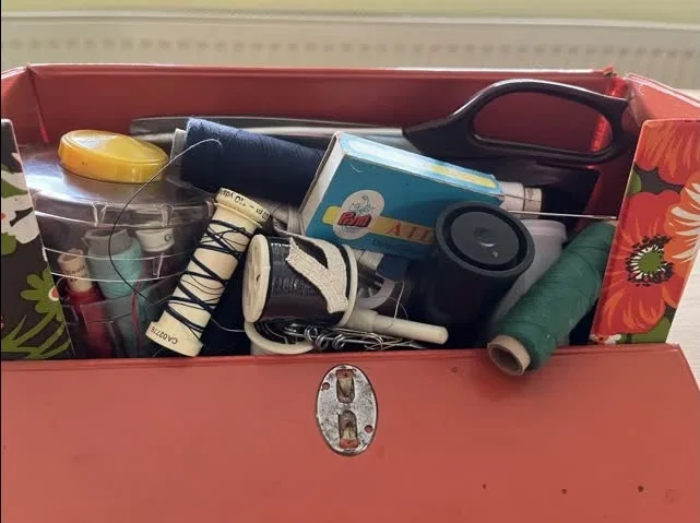 Nähköfferchen aufgeklappt mit Garnrollen, Nadeln und Schere