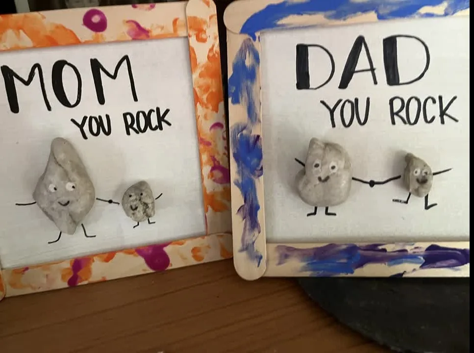 Kleine Steine mit Gesichtern in selbst gebastelten Bilderrahmen, Aufschrift: Mom you rock, Dad you rock