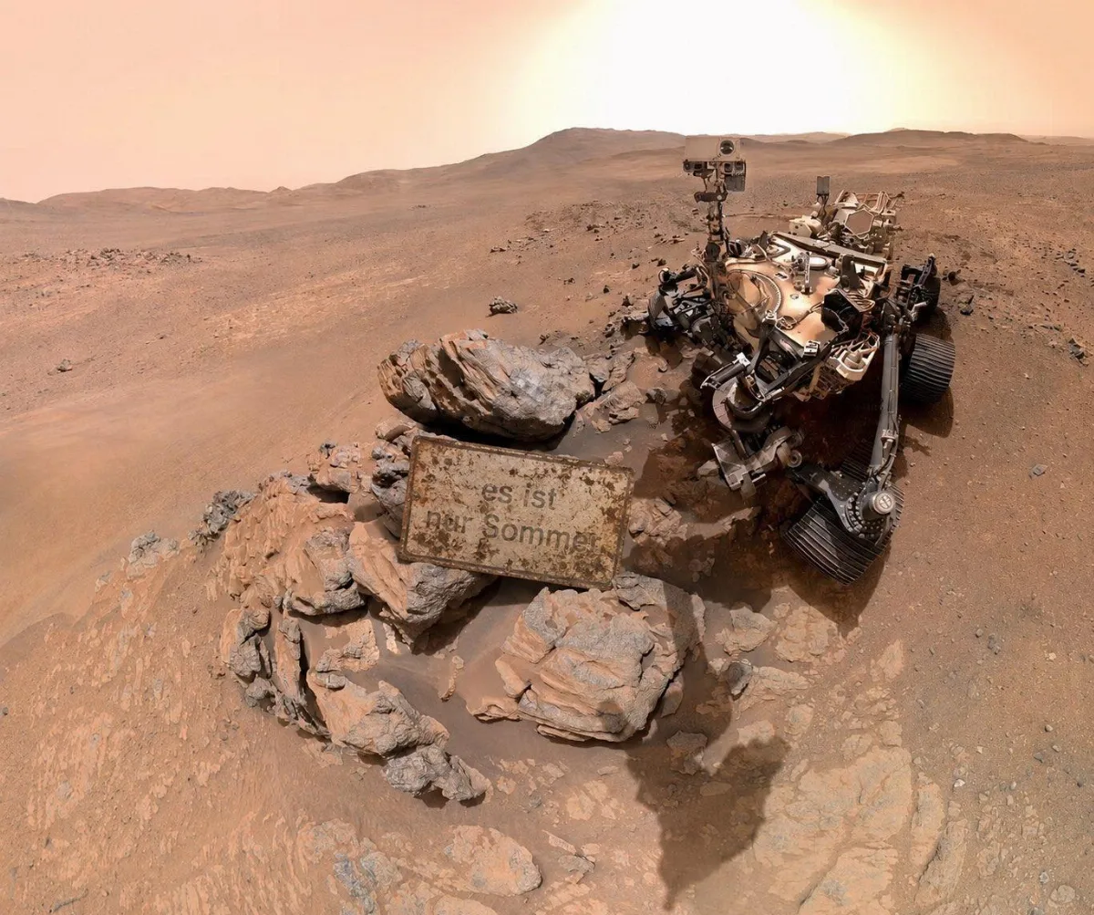 Marsrover vor einem Schild mit der Aufschrift „Es ist nur Sommer“- Bonetti