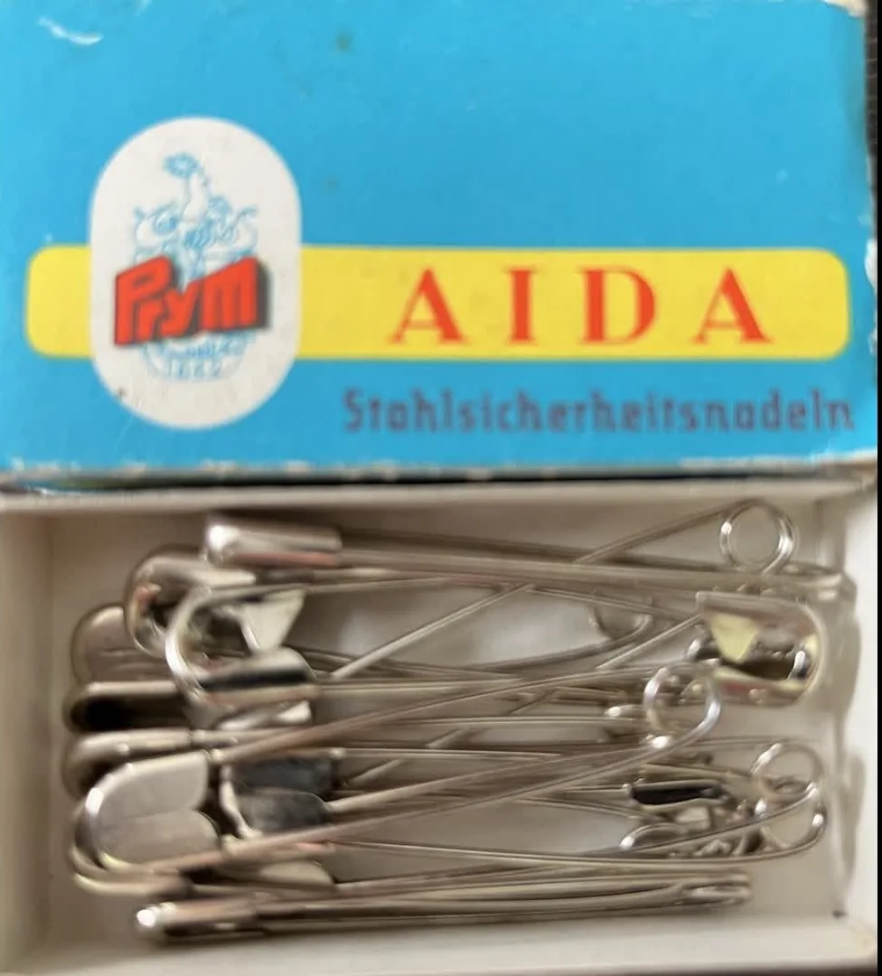 Sicherheitsnadeln in einer Schachtel mit Aufschrift Aida Sicherheitsnaden
