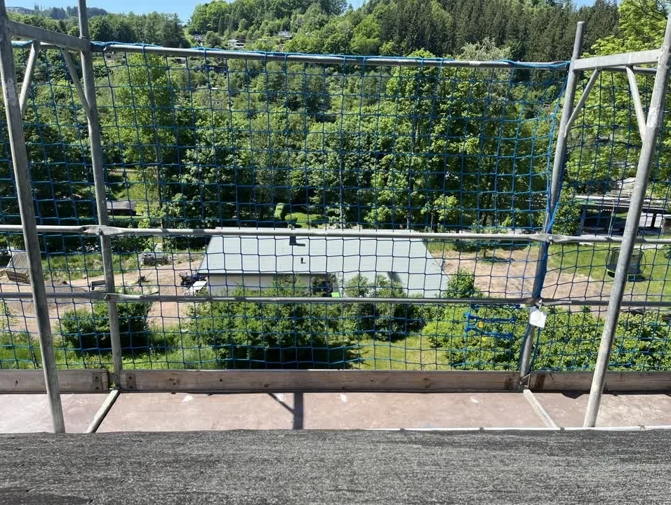 Ein Baugerüst für den Dachdecker durch das geöffnete Fenster. Fotografiert